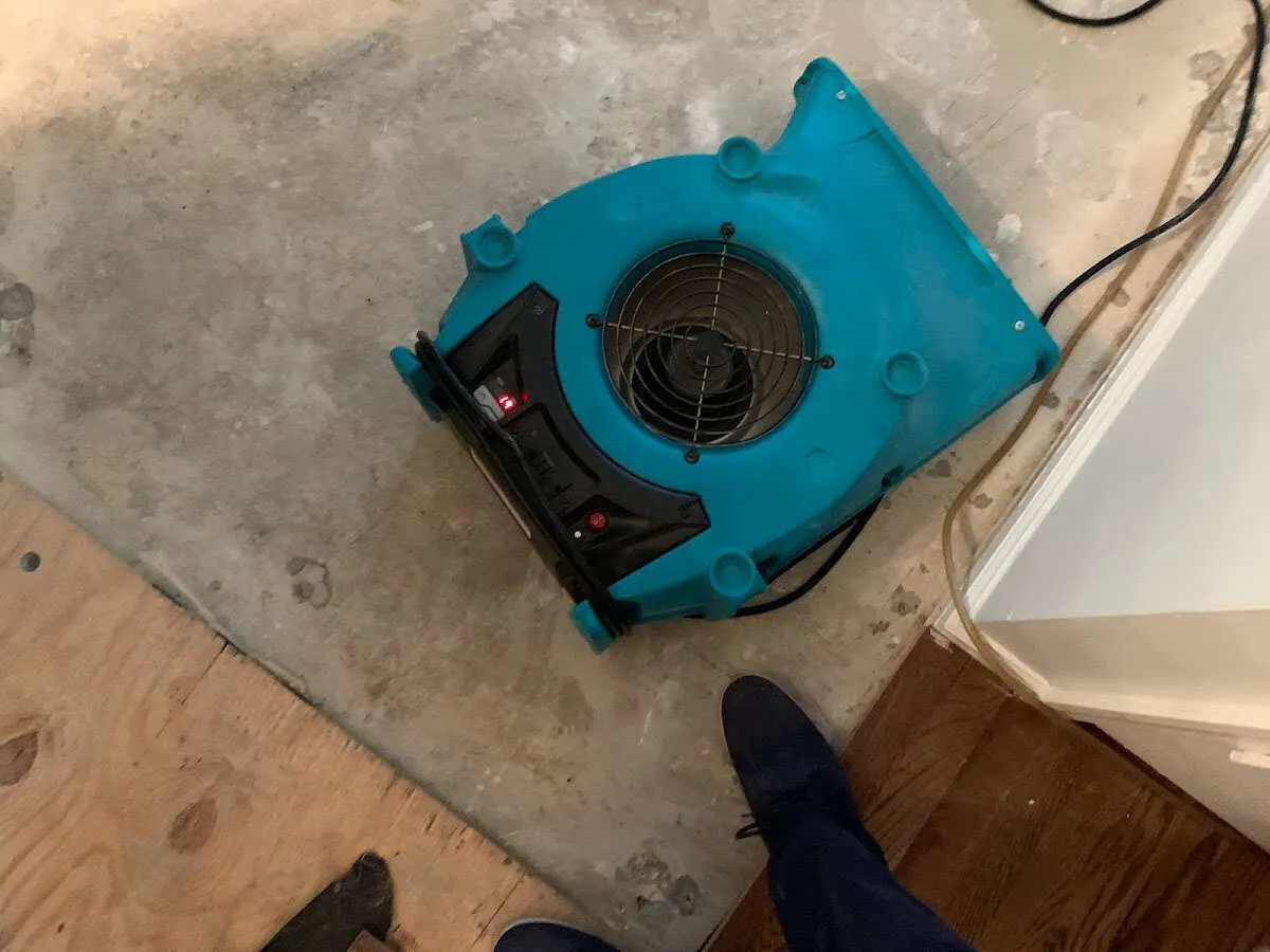Air mover drying subfloor during Commercial Water Damage Restoration in Fort Shawnee
